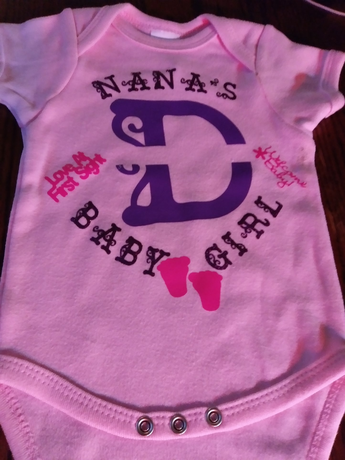 Personalized baby girl's Oneies with the letter D and name in the middle.
