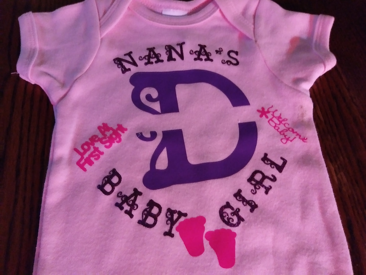 Personalized baby girl's Oneies with the letter D and name in the middle.